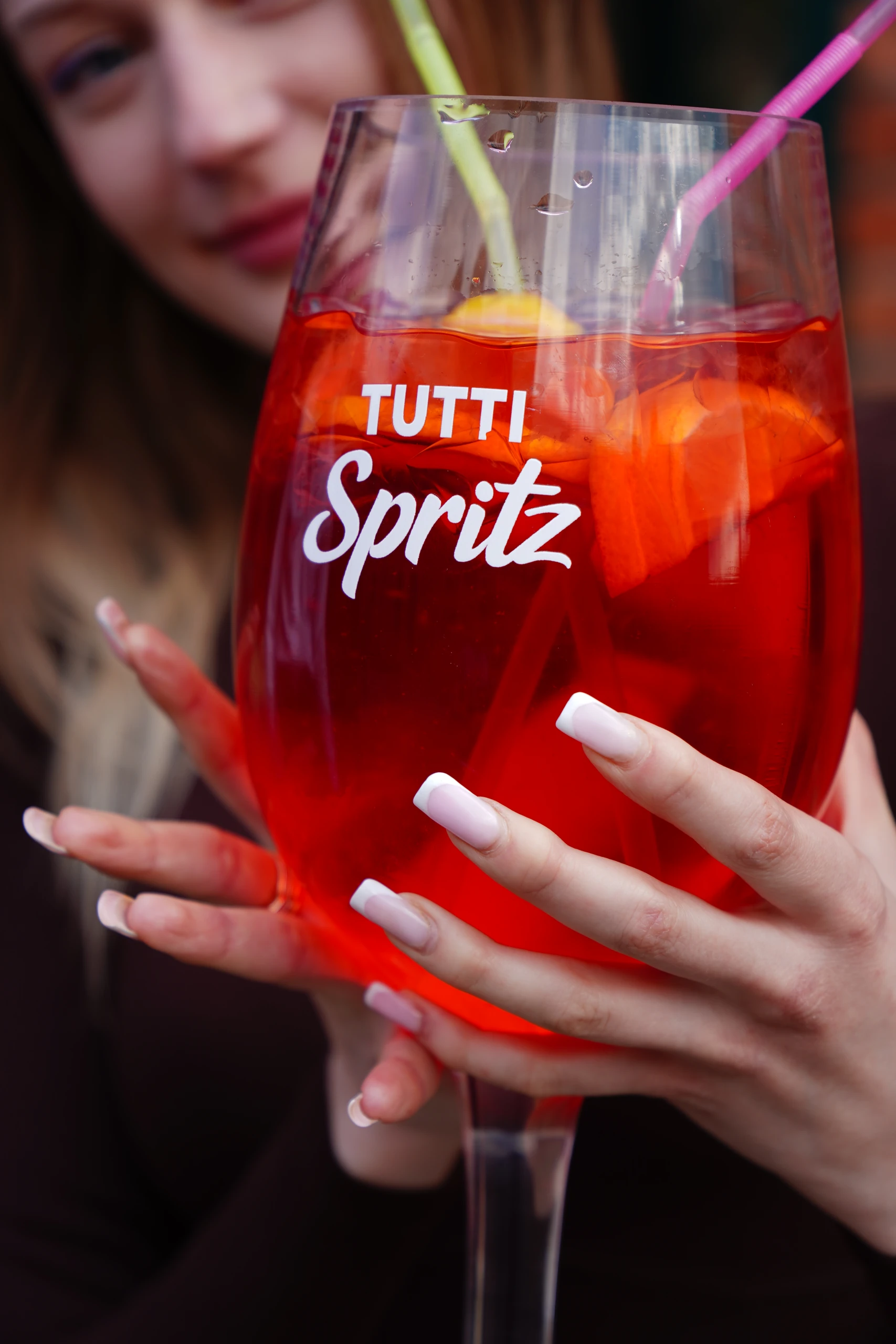 Litrowy Spritz w wielkim kieliszku trzymanym w dłoniach.